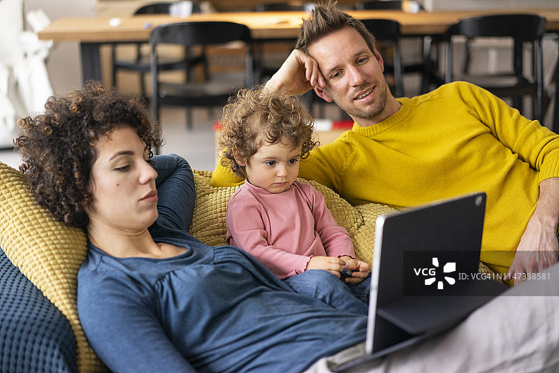 一家人躺在沙发上用平板电脑看电影图片素材