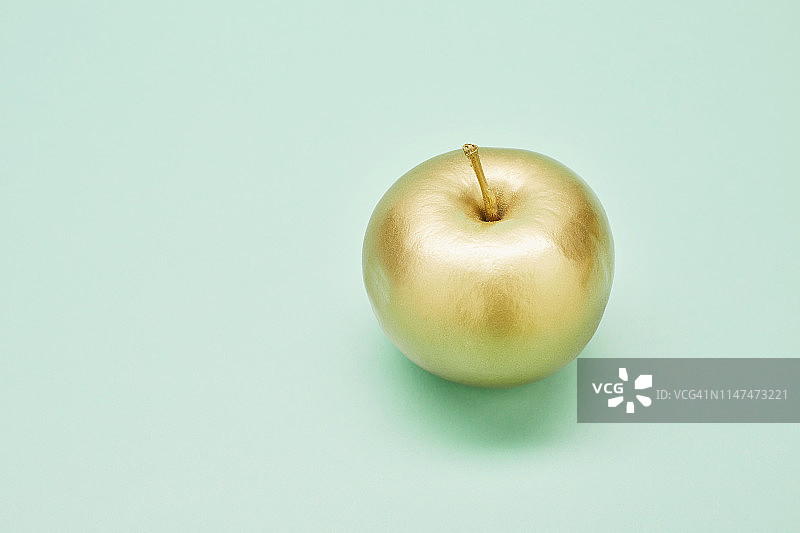绿松石背景下的金苹果静物画图片素材