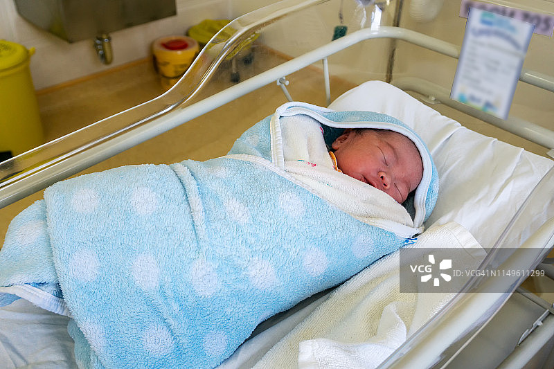 刚出生的婴儿在医院的摇篮里睡觉图片素材