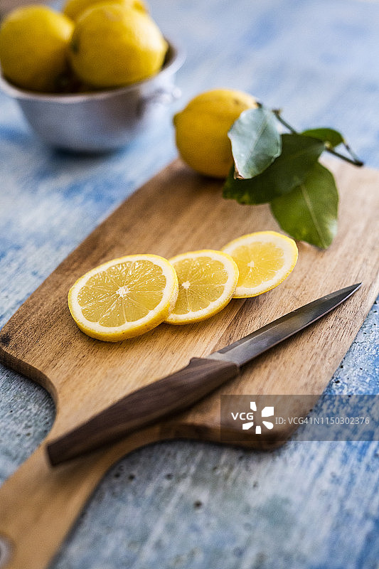柠檬片，菜刀和整个柠檬放在木板上图片素材
