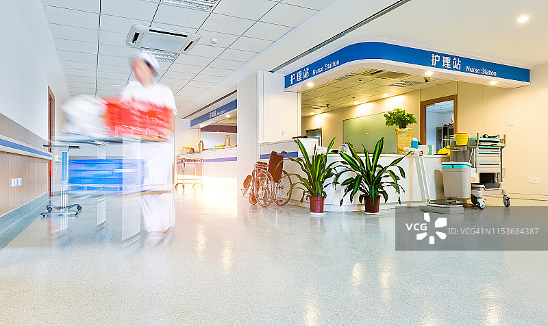 身着医疗制服的模糊人影穿过医院的走廊图片素材
