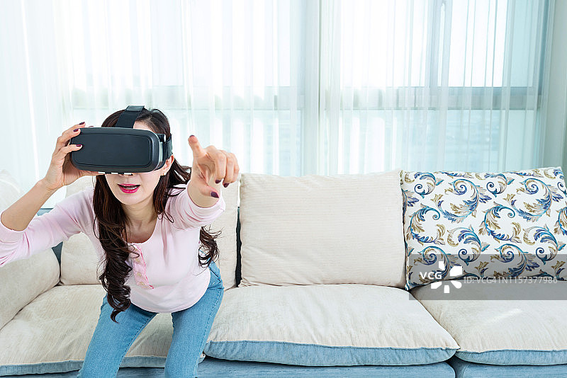 在家戴着虚拟现实模拟器的女人图片素材