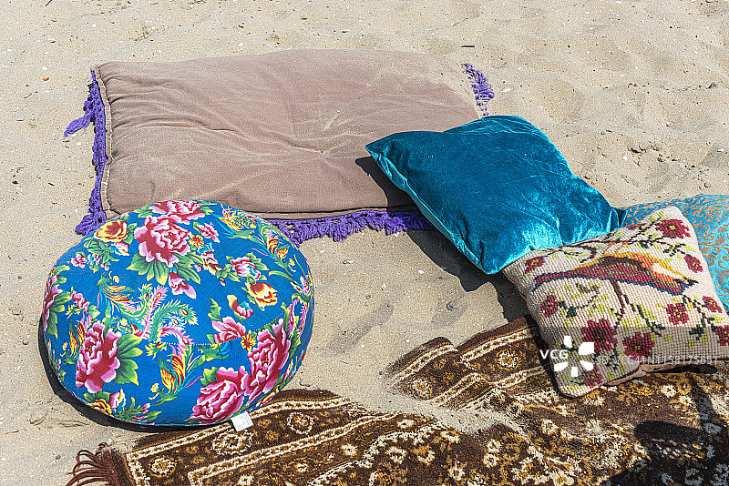 五颜六色的枕头躺在沙滩上图片素材