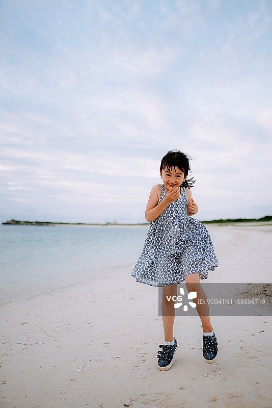 可爱的混血女孩在海滩上跳，冲绳，日本图片素材