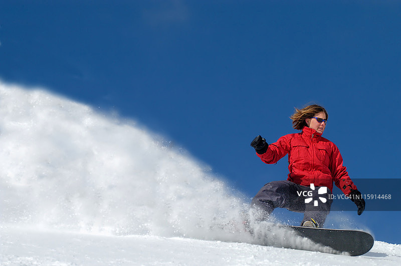 滑雪时穿着红色夹克的女人图片素材