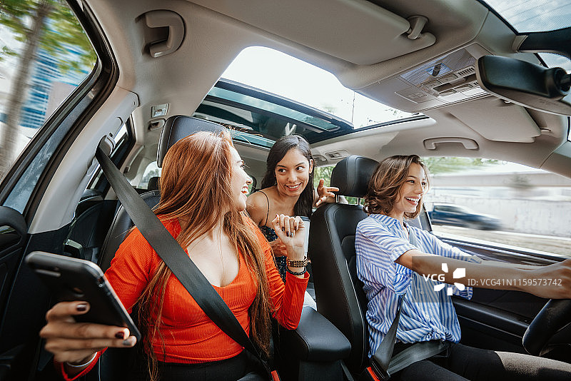 千禧一代女性共用汽车，使用智能手机上的GPS。图片素材