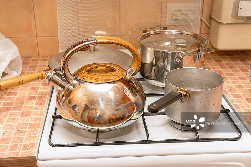 平底锅，煎锅和煤气炉上的水壶图片素材