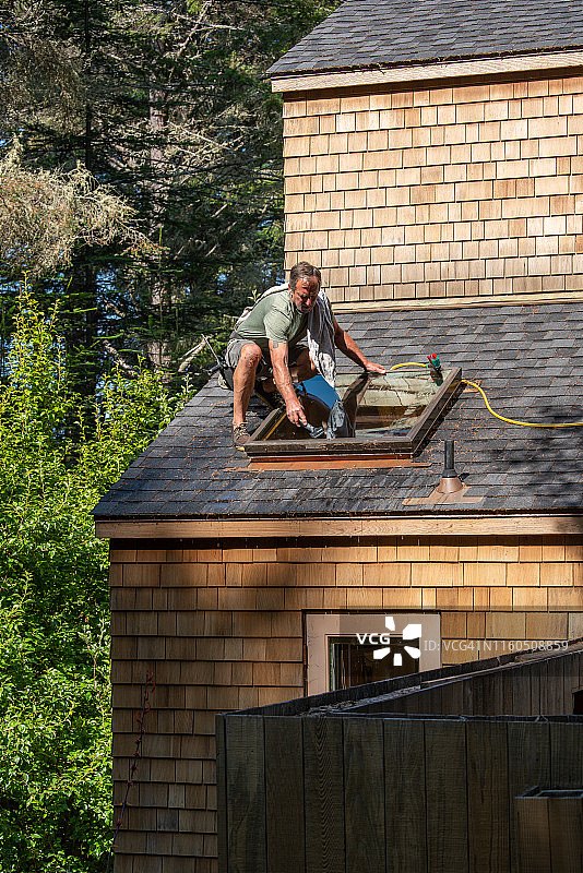 一个人在清洗屋顶上的天窗图片素材