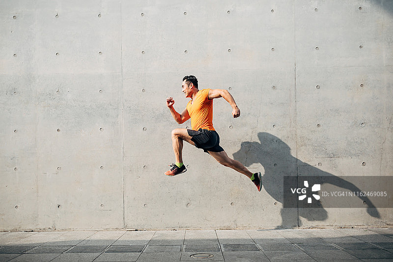 运动亚洲中间人跑和跳跃的快门。健康与健身理念。图片素材
