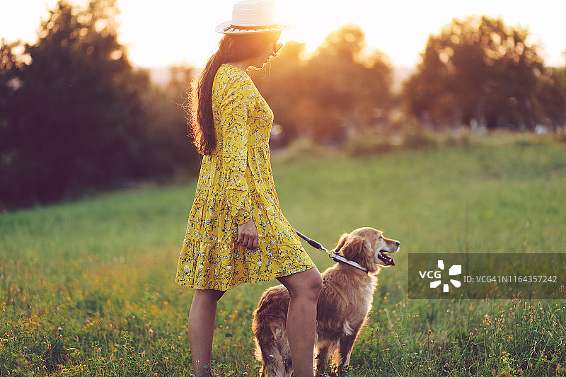 女人和狗在大自然中欣赏日落图片素材