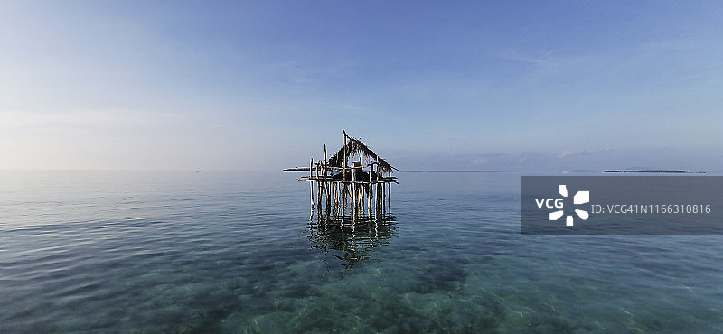 海上吉普赛传统房屋在宁静的早晨与水晶清澈的水和蓝色的天空。图片素材