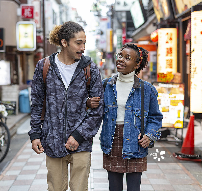 快乐浪漫的混血儿旅游夫妇在日本东京的街道上购物和观光图片素材