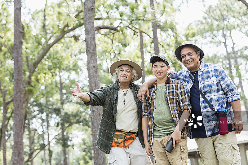几代拉美裔家庭在树林里徒步旅行图片素材