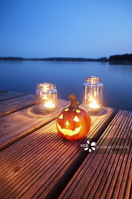 万圣节南瓜灯与蜡烛在码头在一个湖在晚上的生活图片素材