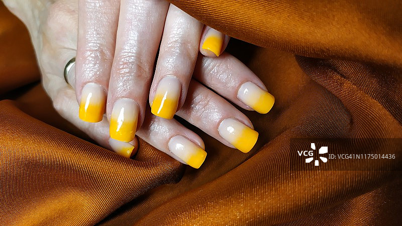 特写的女人手指与指甲艺术美甲黄色渐变图片素材