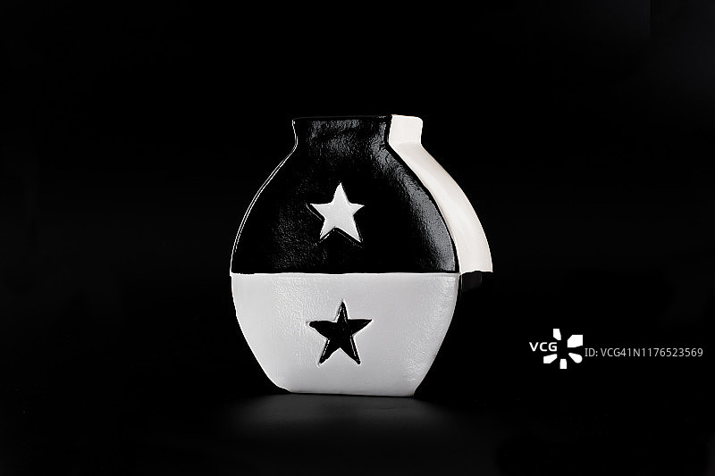 黑白陶瓷花瓶孤立在黑色背景上。图片素材