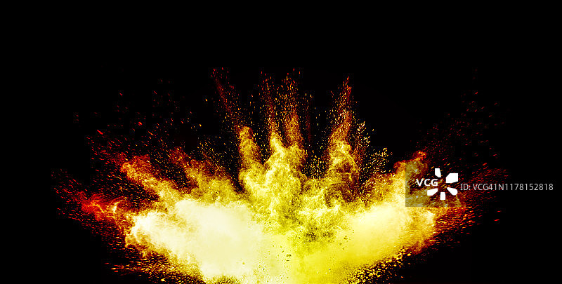 在黑色的背景上，由黄色和橙色的粉末颗粒和烟雾组成的云团撞击而成的爆炸。图片素材