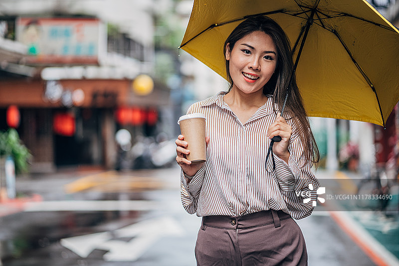 台北街道上拿着雨伞的女士图片素材