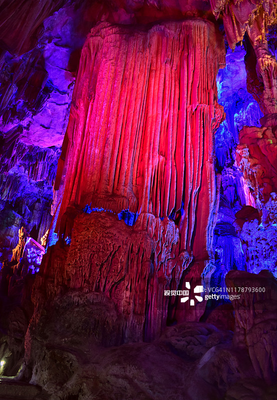 中国桂林芦笛洞中美丽而引人注目的岩层，钟乳石和石笋被人工照明染成了颜色图片素材