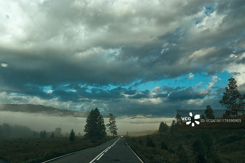 在阴天有雾的情况下，从山口通往山谷的小路图片素材
