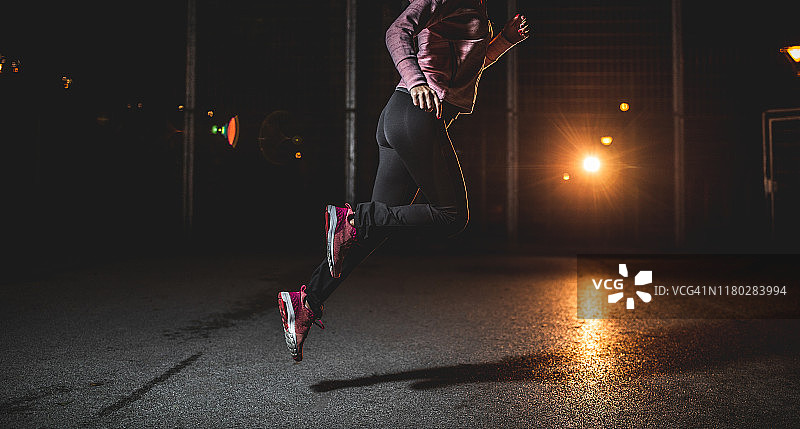 年轻的女运动员在晚上跑步图片素材