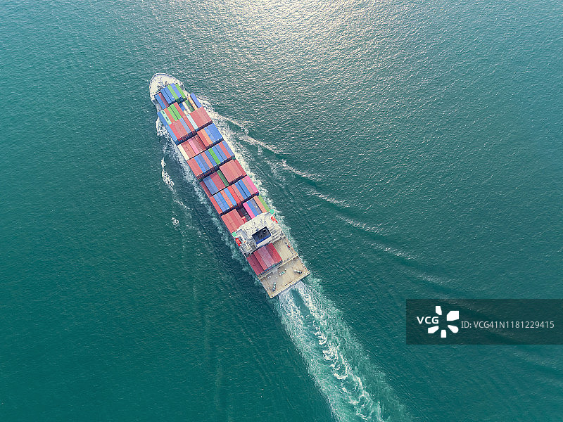 鸟瞰图集装箱货轮全承运人集装箱在绿色海洋上的业务物流，进出口，海运或运输。图片素材