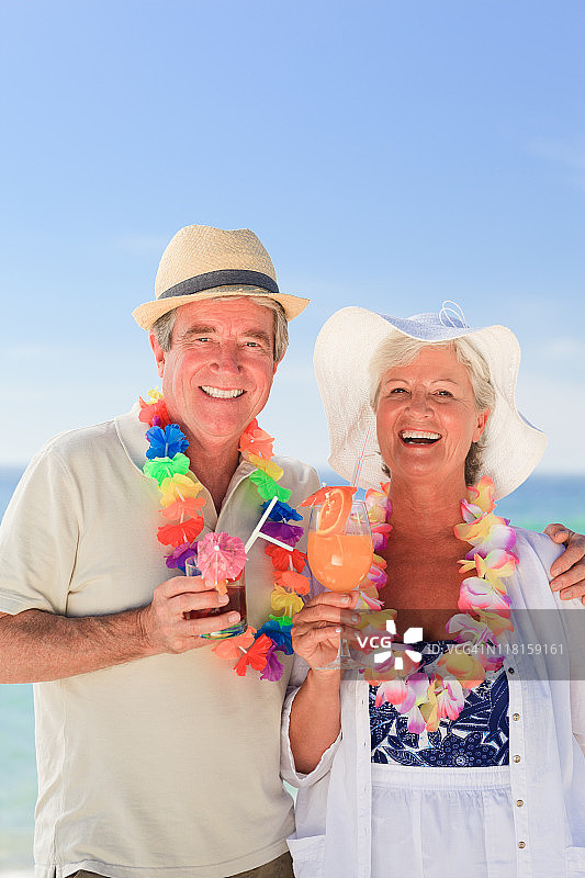 一对老夫妇在海滩上喝鸡尾酒图片素材