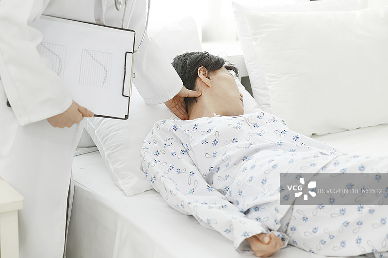 医生在床上检查病人的颈部图片素材