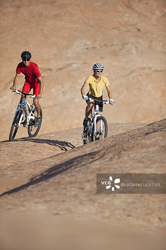 犹他州摩押附近骑山地自行车的男人和女人图片素材