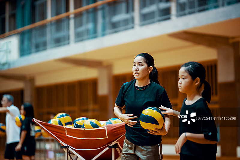 女教练在排球团体练习中给年轻女孩提供建议和指导的女教练图片素材
