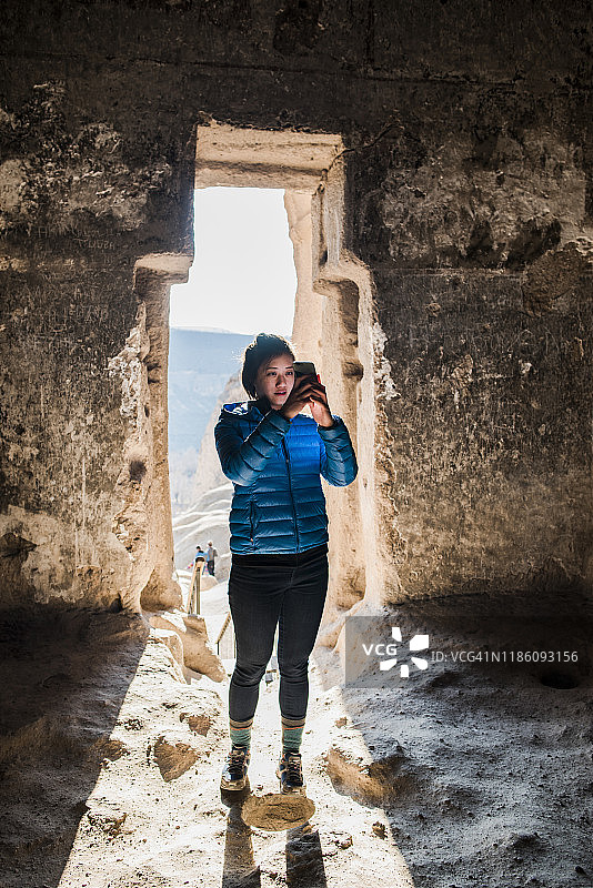 Woman taking photograph in Selime Monastery, Göreme, Cappadocia, Nevsehir, Turkey图片素材