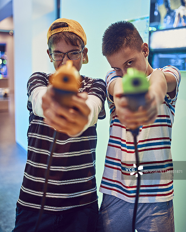 青少年朋友在游乐场用手枪射击的肖像图片素材