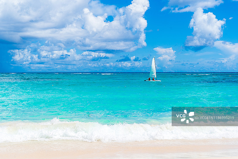 风景优美的海滩与绿松石水域和帆船在蓬塔卡纳，多米尼加共和国。图片素材