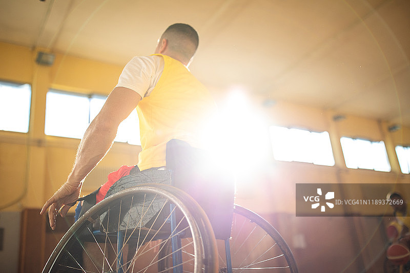 适应性运动员坐轮椅在室内篮球场打篮球图片素材