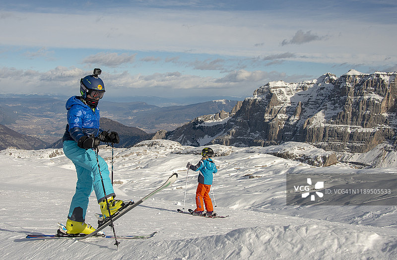 意大利多洛米蒂，麦当娜迪坎皮格利奥的帕索格罗斯特滑雪场，男孩们在滑雪坡上玩耍图片素材