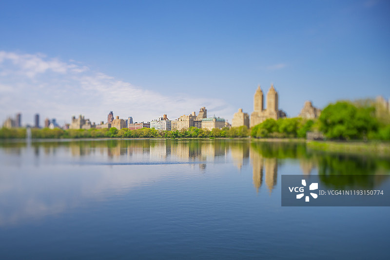 2019年5月8日，美国纽约，中央公园西历史街区的建筑和一排排新鲜的绿叶映入中央公园水库。图片素材