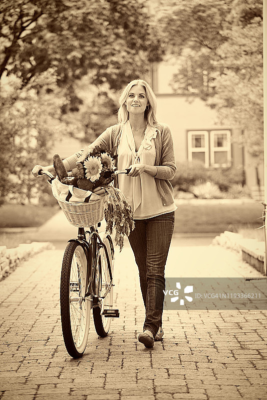 复古色调的年轻女子骑自行车去杂货店市场购物图片素材