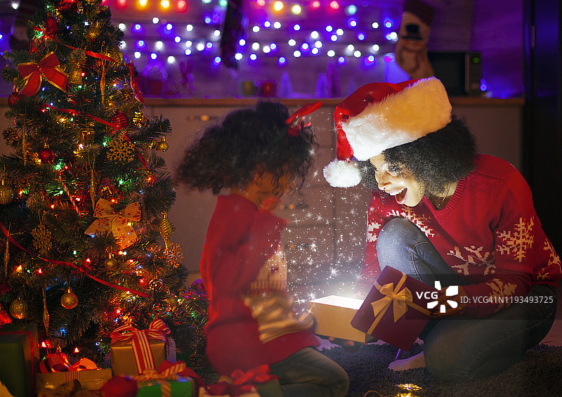 非裔美国家庭打开圣诞魔术照明礼物图片素材