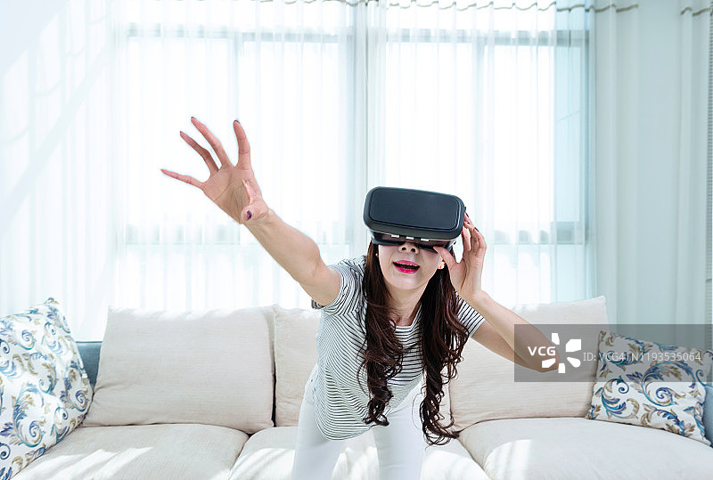 在家戴着虚拟现实模拟器的女人图片素材