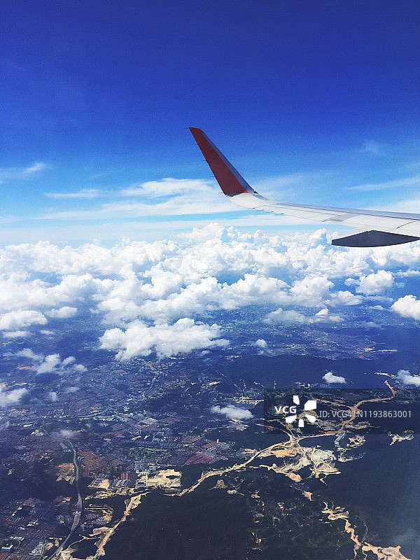 这是一个阳光明媚的日子，从商业航班的窗口可以看到美丽的蓝天和棉花般的白云。图片素材