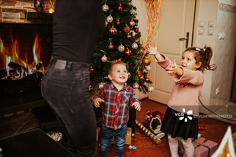小女孩和小男孩在圣诞节和妈妈一起玩图片素材
