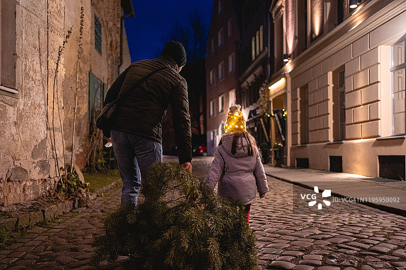 爸爸和女儿刚买了一棵圣诞树图片素材