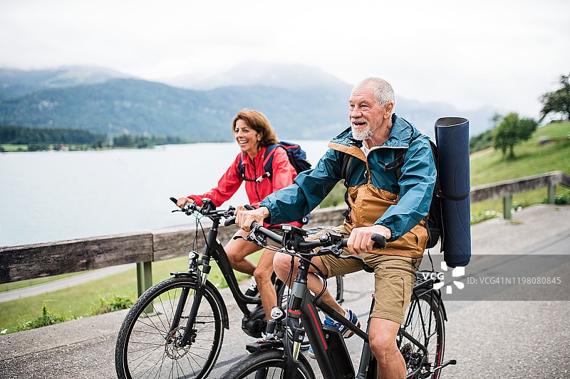 老两口带着自行车在自然之路上骑行度假。图片素材