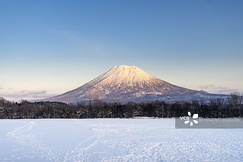 日本北海道二世子附近被雪覆盖的小富士山Yotei和村庄的美丽风景图片素材