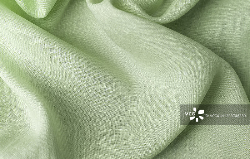 用大麻和绿叶制成的纺织品。织物作为背景，织物有波浪褶皱。图片素材