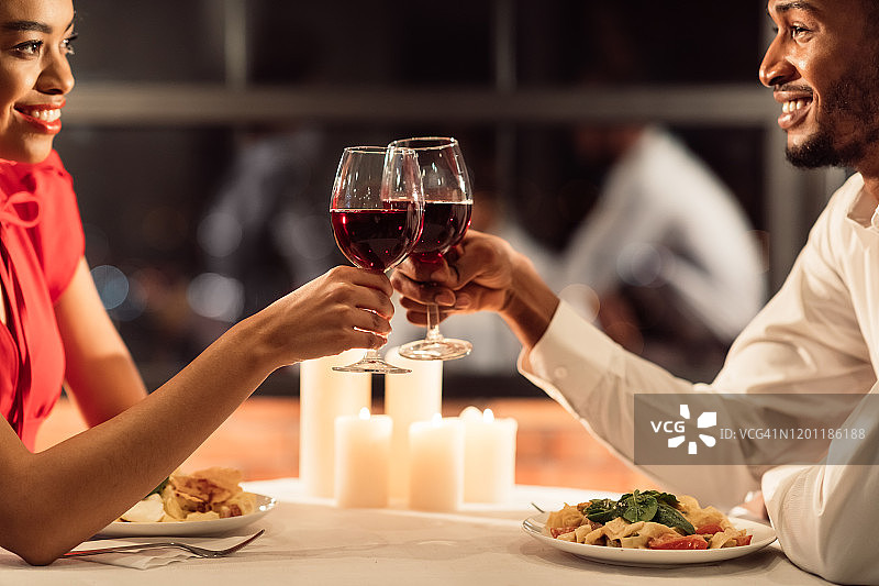 相爱的夫妇祝酒碰杯庆祝情人节在餐厅，裁剪图片素材