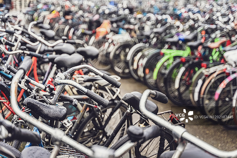 模糊的背景不同的自行车在停车场。在阿姆斯特丹停放自行车图片素材