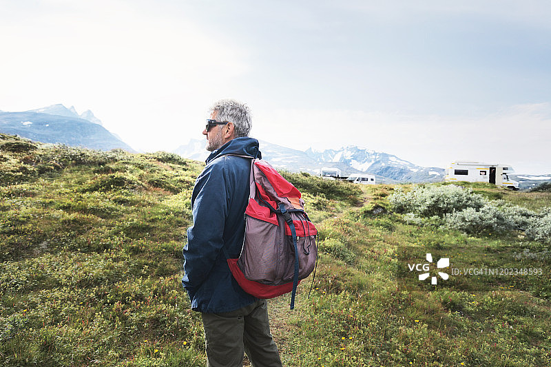 一位老人背着背包在山里旅行图片素材