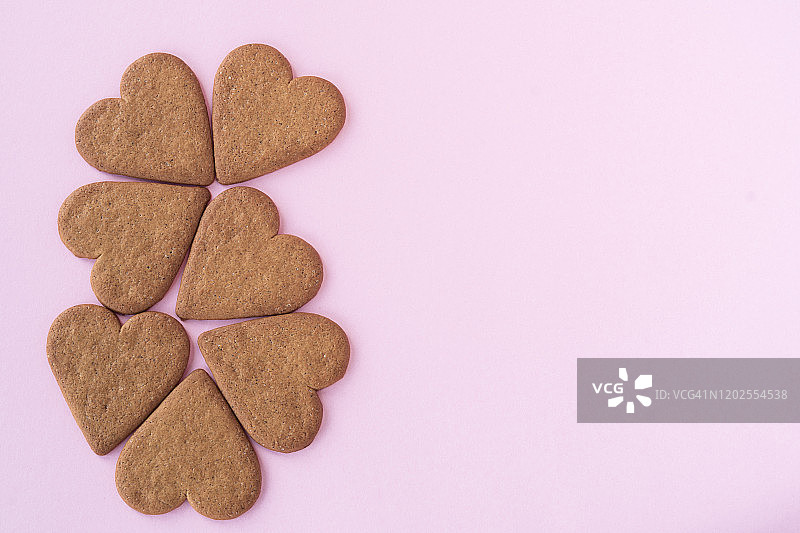 心形姜饼饼干，肉桂粉背景与复制空间。爱情和浪漫主义的概念图片素材