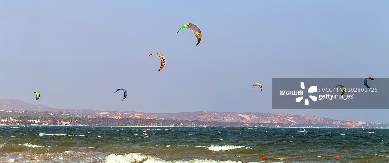 风筝冲浪者在海浪中溅起海水，吸引人的运动大海。梅尼可海滩。越南。图片素材